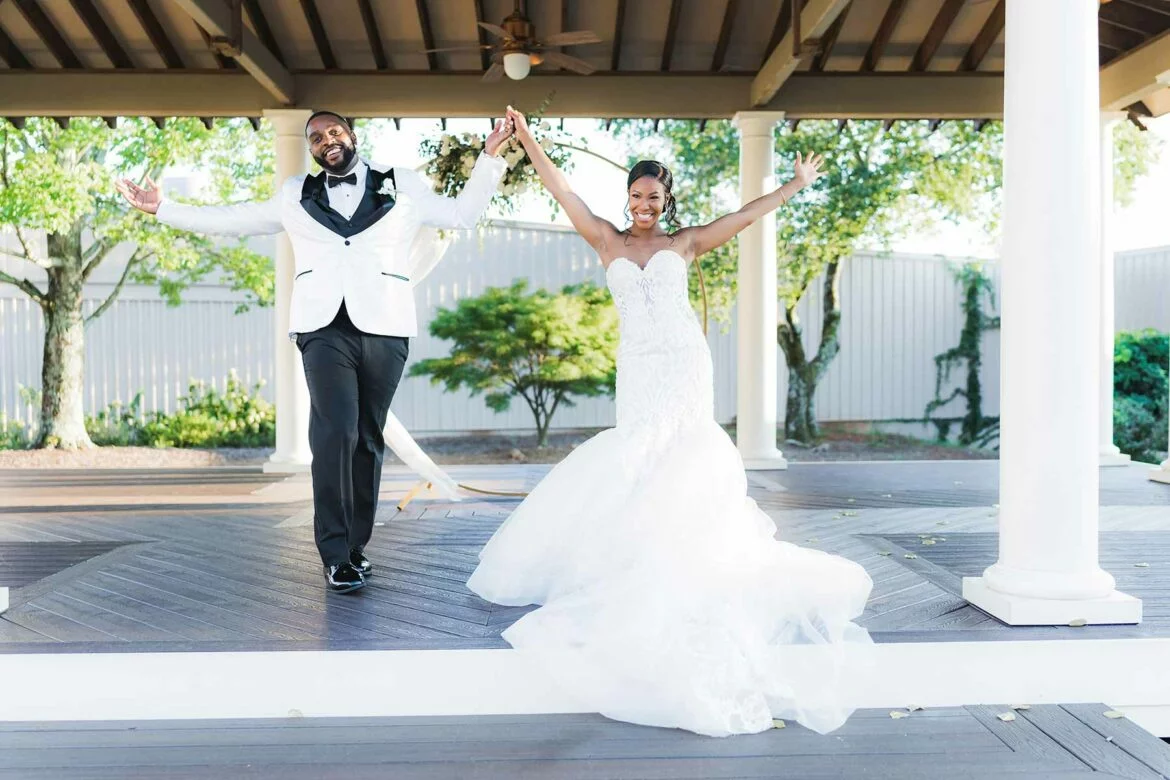 Newlyweds make their wedding reception entrance holding hands with arms raised