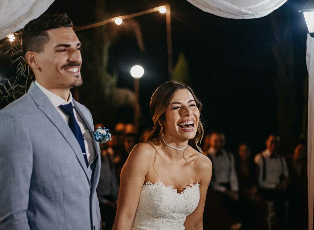 Smiling bride and groom smiling during their wedding entrance