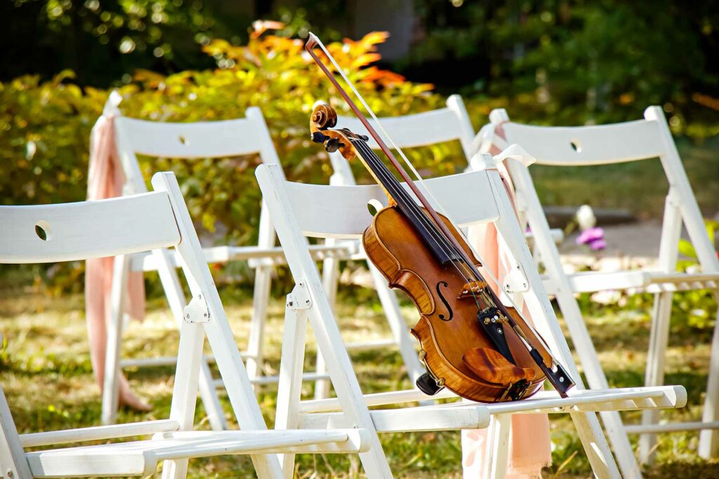 A violin resting on a chair at a wedding