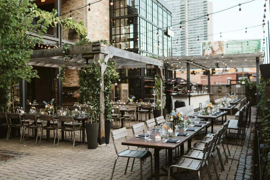 The Dawson outdoor wedding venue space featuring rustic wooden tables decorated with floral arrangements and greenery