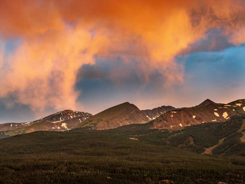 A sunset photo of clouds above mountains in Colorado honeymoon destination Breckenridge
