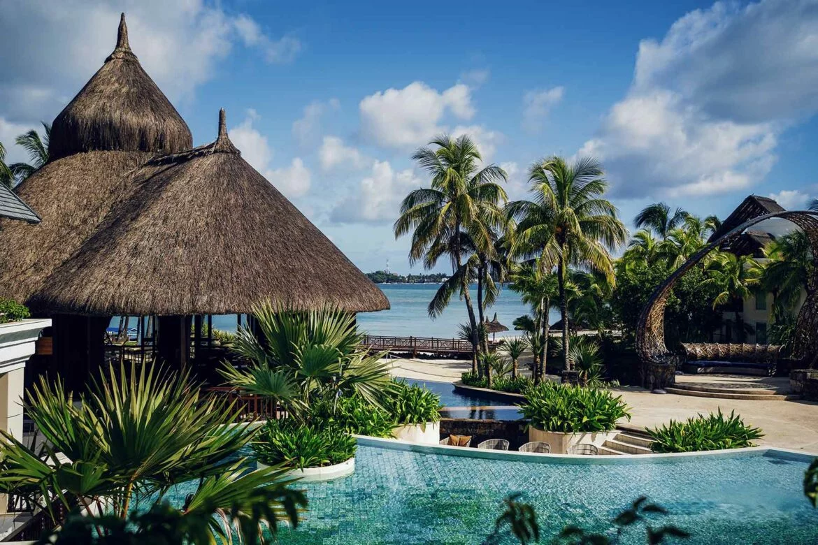 Thatched roof buildings and pool at the Shangri-La Le Touessrok, a Mauritius honeymoon destination