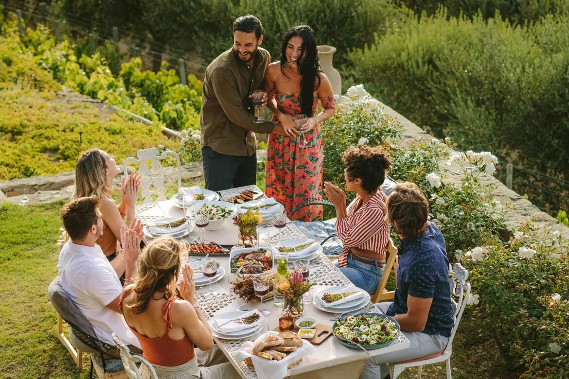 A couple celebrating with friends around a table at a wedding shower in a garden setting