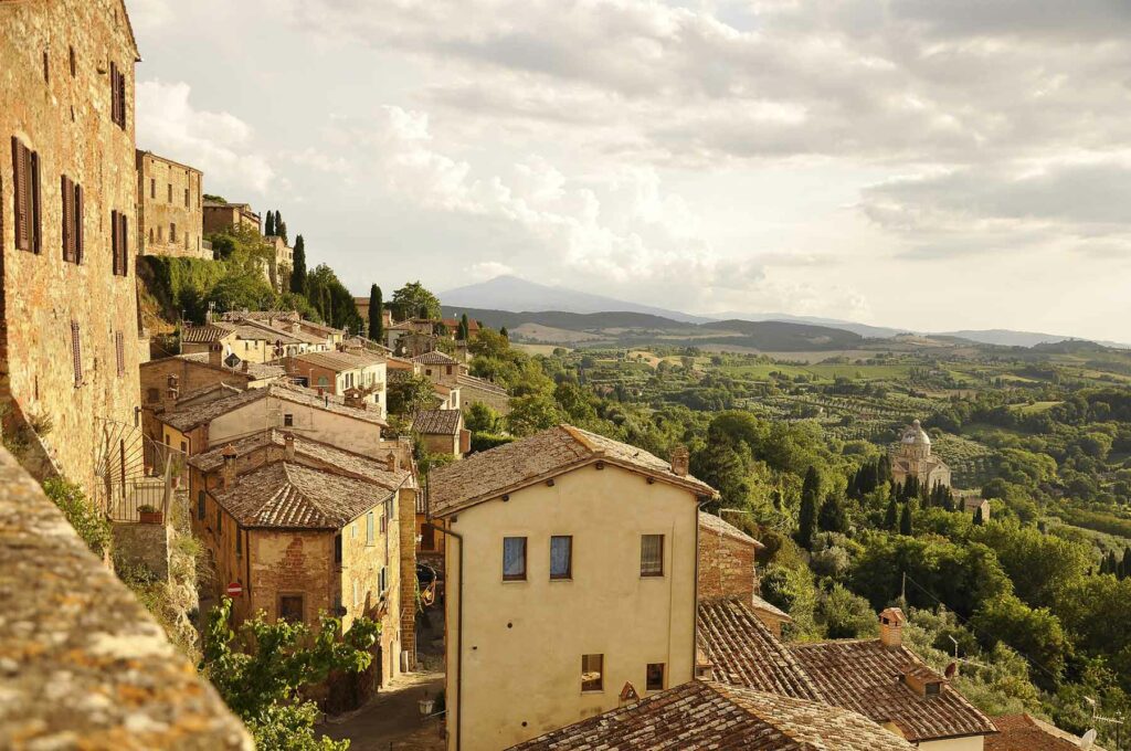 A view of Tuscan villas perched in the hills overlooking rolling green vineyards