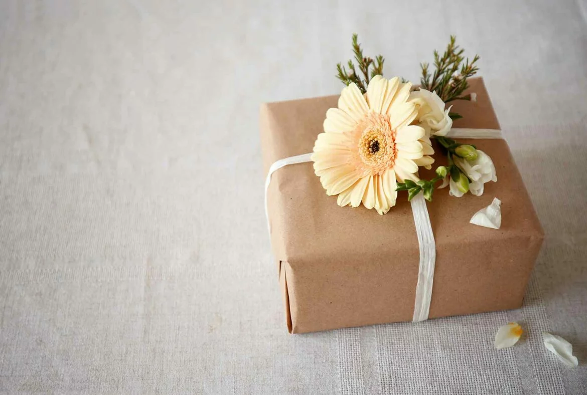 Wedding registry gift wrapped in kraft paper and tied with ribbon and a flower