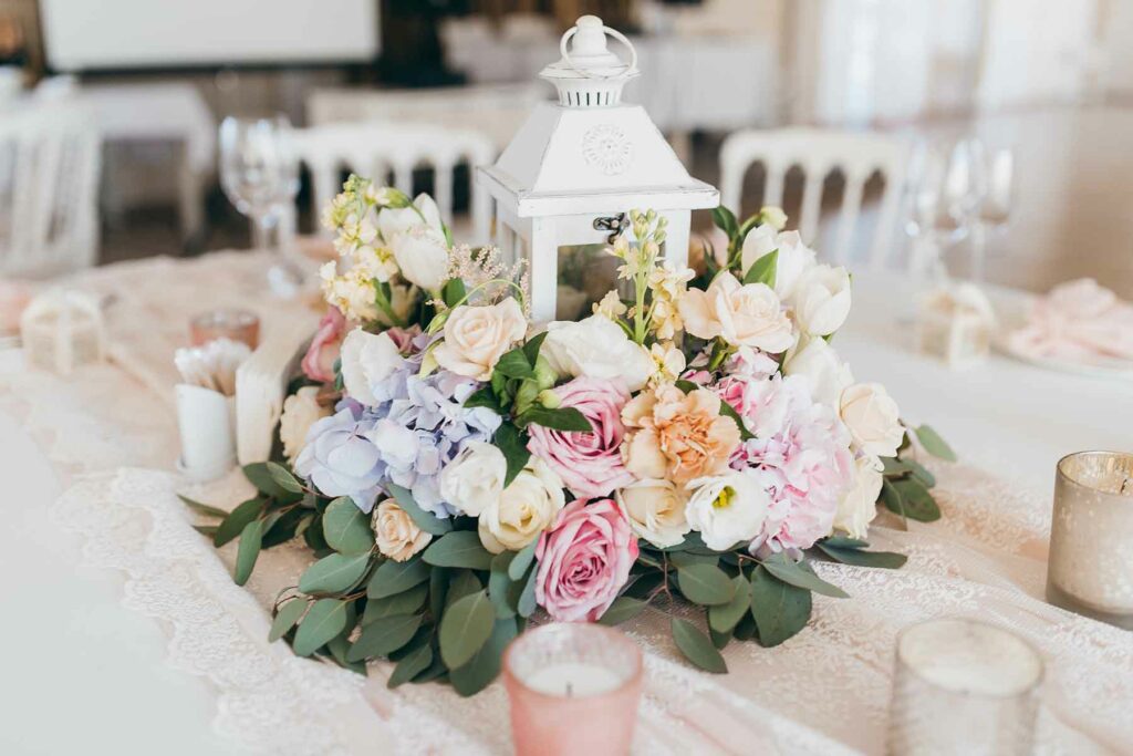 A spring wedding centerpiece with fresh flowers including garden roses and greenery