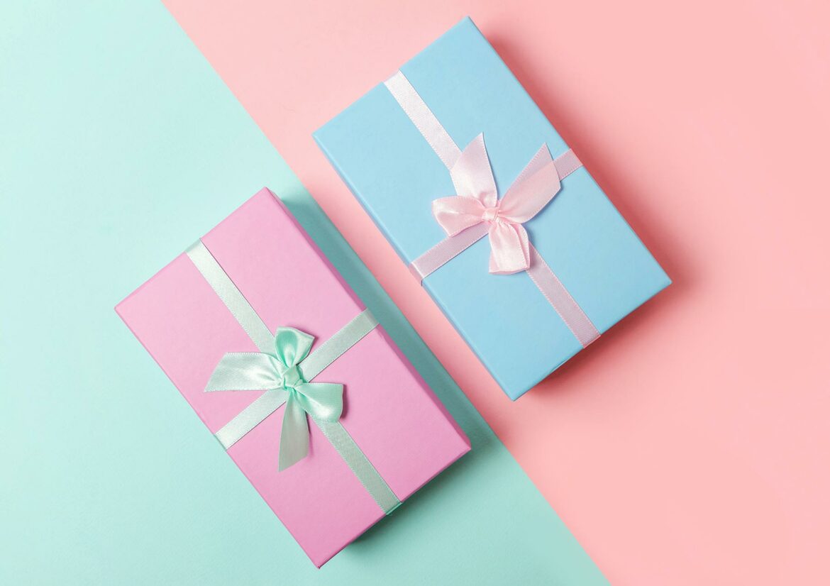 Two wedding gifts wrapped with ribbon on a color blocked background