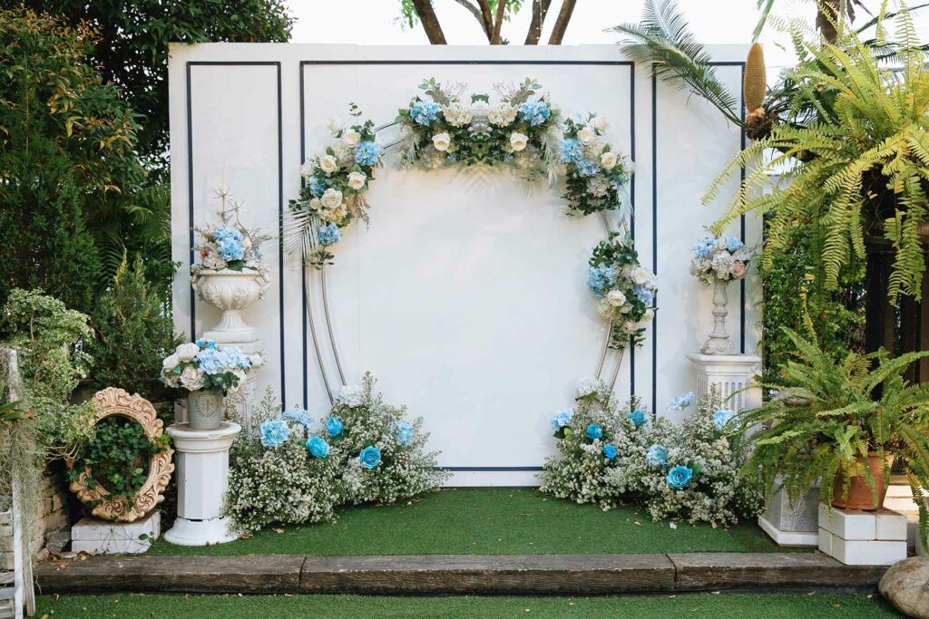Flowers around an arch creating a photo backdrop surrounded by trees