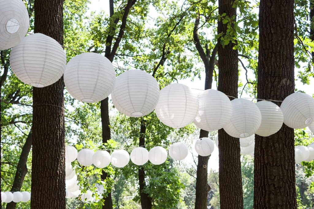 White paper lanterns strung between trees