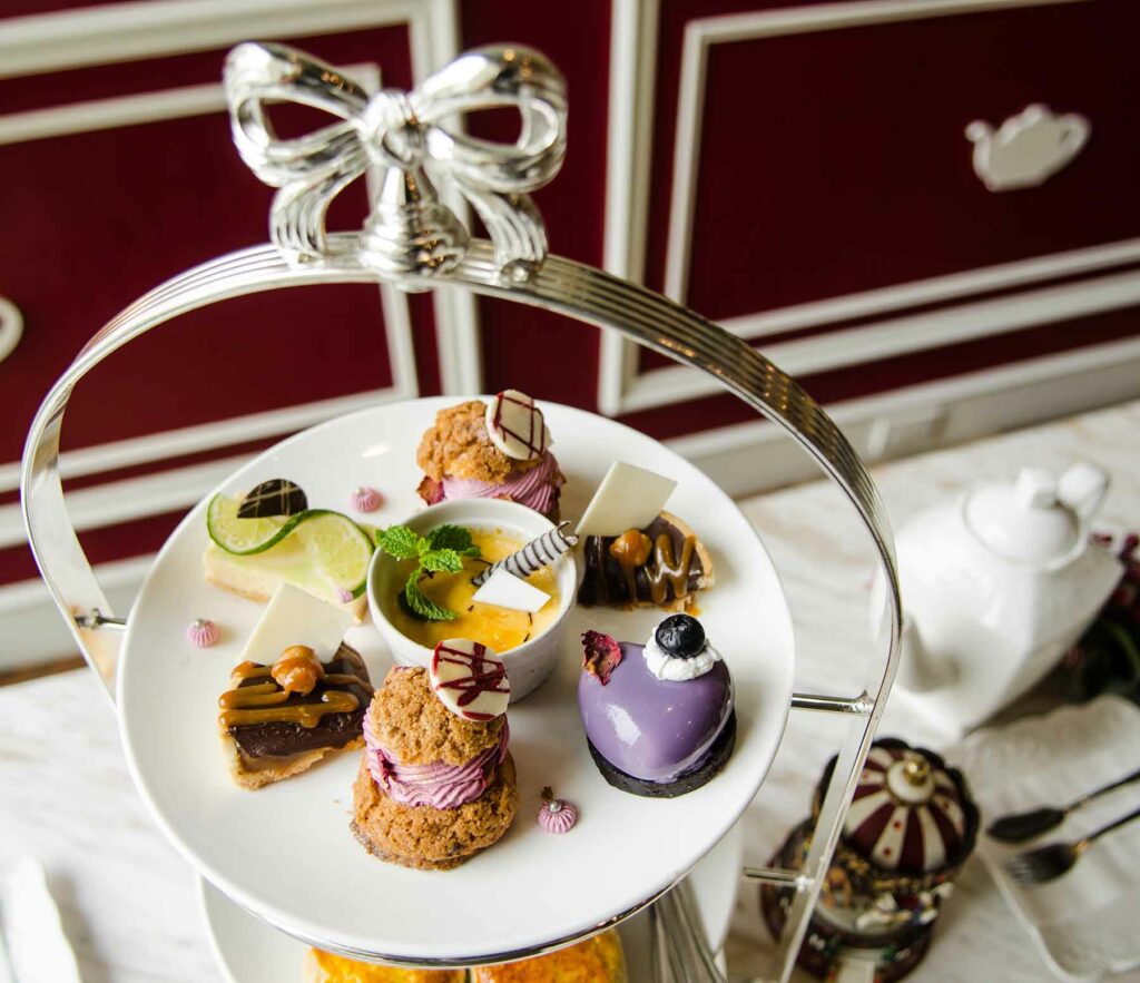 Afternoon tea tray with a silver bow at the top and seven small desserts on the top tier