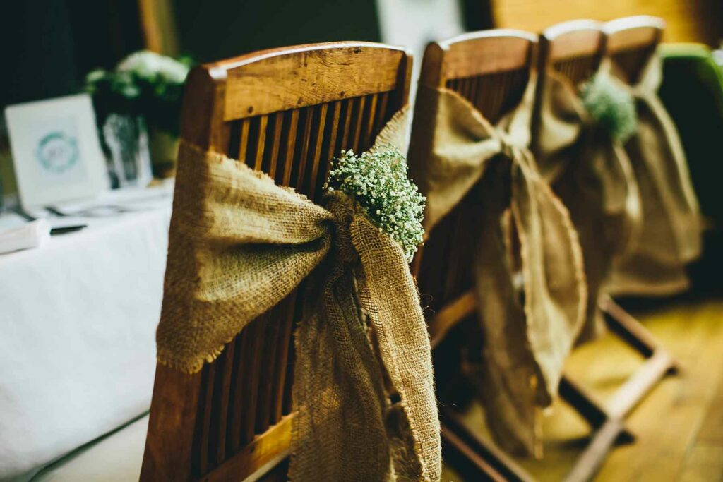 Burlap tied around a wooden chair with baby's breath