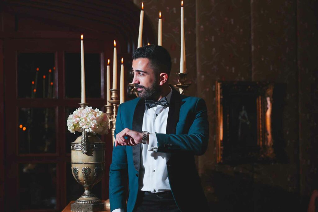 A groom wears a dark blue brocade tux with satin lapels