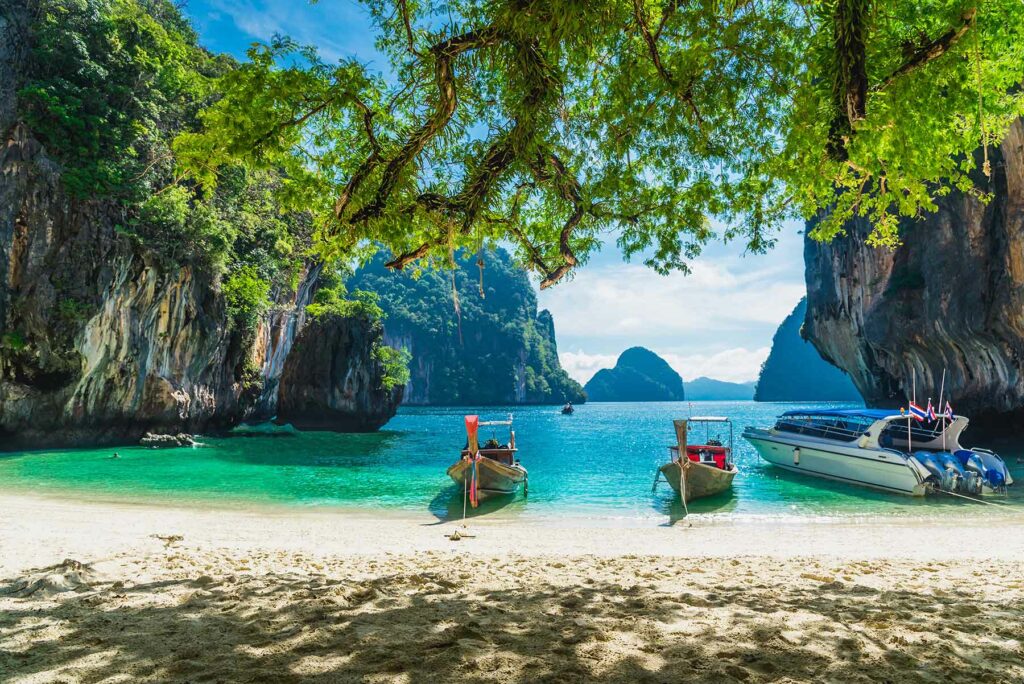 Long-tail boats on the turquoise blue waters of a Thailand beach