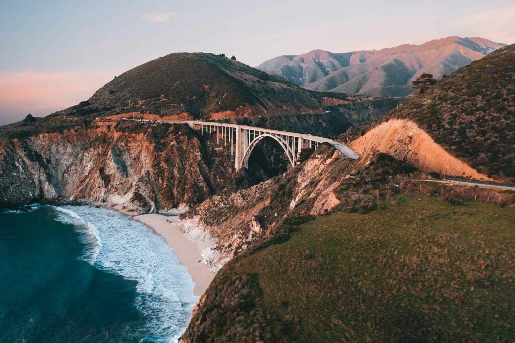 Bixby Bridge in Big Sur with water in the foreground and mountains in the back