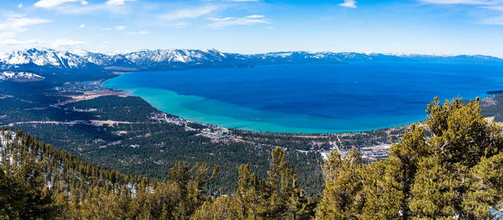 An aerial view of Lake Tahoe and the snow-capped mountains