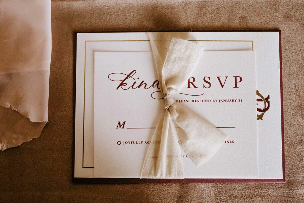a wedding invitation suite RSVP card tied with a satin ribbon
