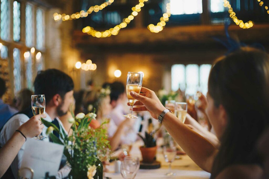 A guest raising a toast at a pre-wedding event