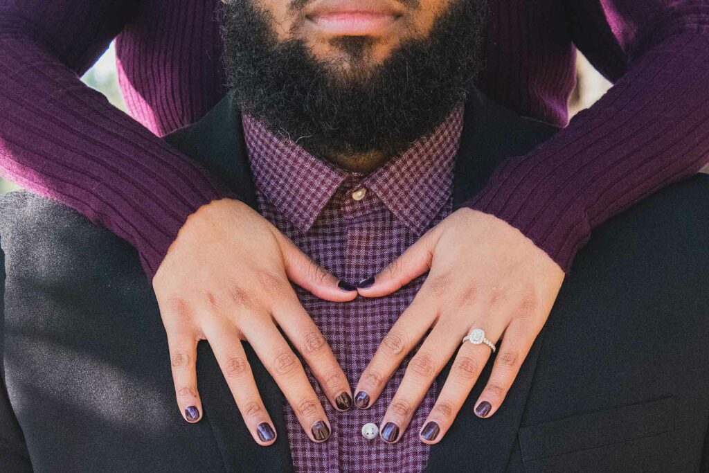 What to wear in engagement photos: a man and woman wearing a purple sweater that complements a purple flannel and an engagement ring
