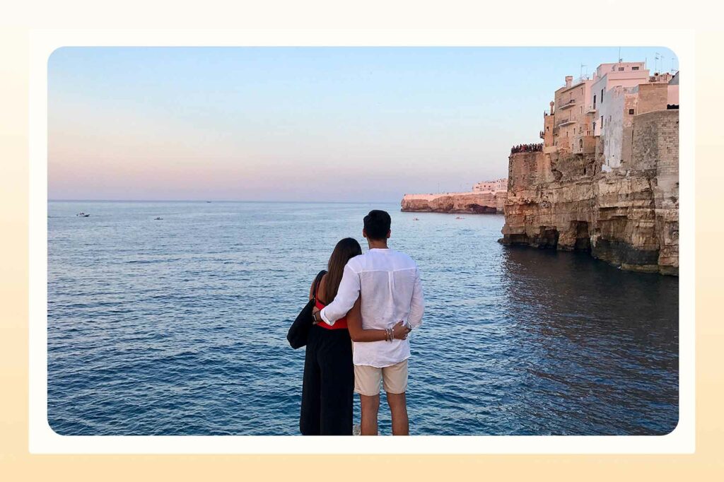 A couple looking out at the water during a beach proposal