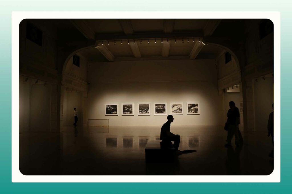 A person sitting in a darkened art gallery