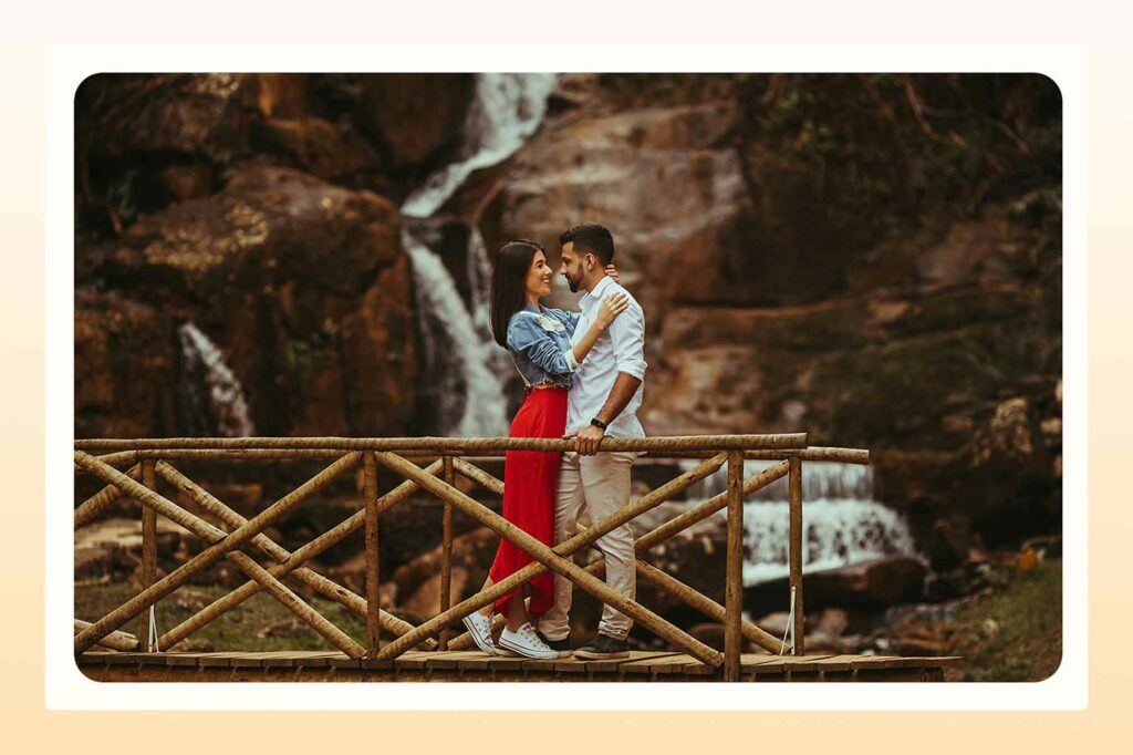 A couple embracing in front of a waterfall