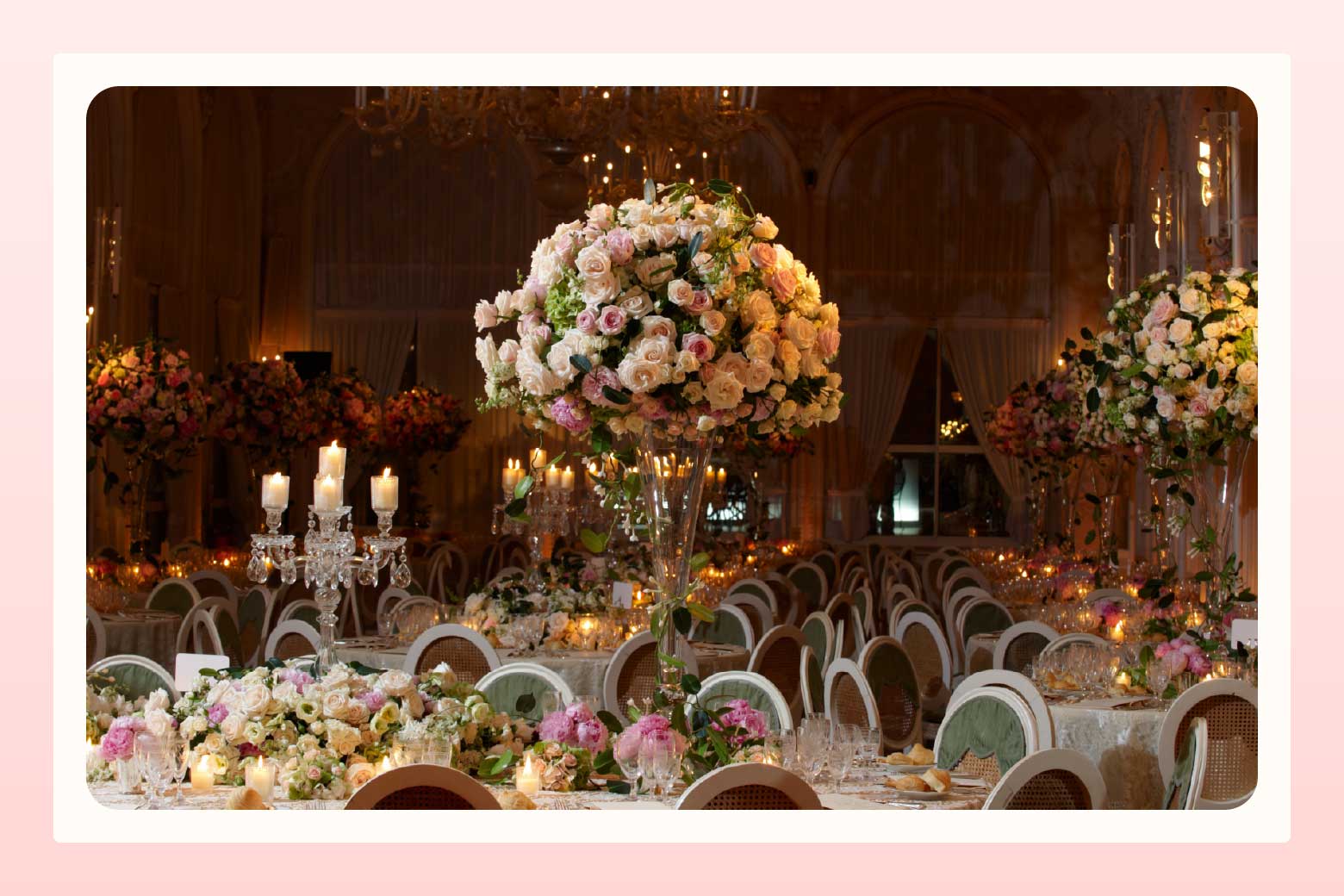 Elaborate wedding reception set-up with tables with candelabras and tall centerpieces of large bouquets or pale pink roses