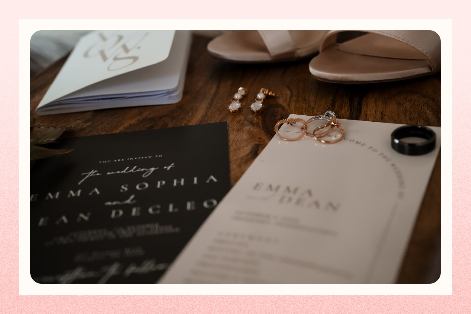 Wedding invitation for Emma and Dean laying on table with wedding bands, earrings, and bridal shoes alongside