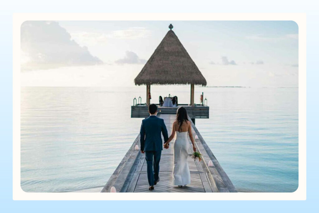 couple holding hands walking on a pier during their wedding