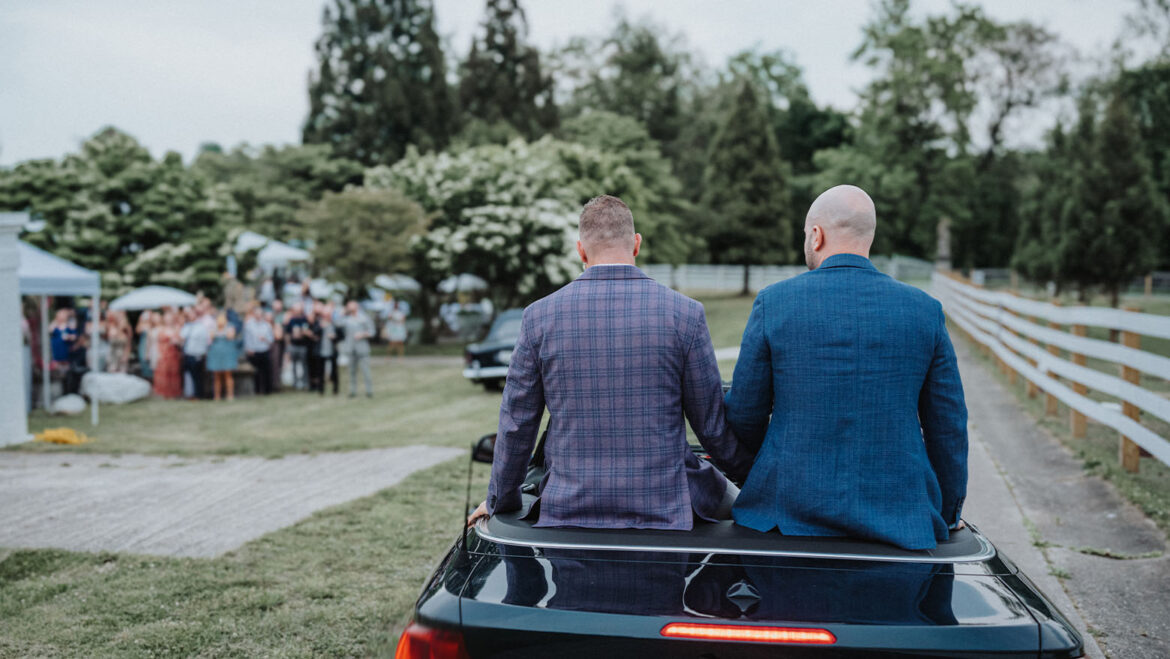 Grooms arrive at the ceremony riding in a convertible car.