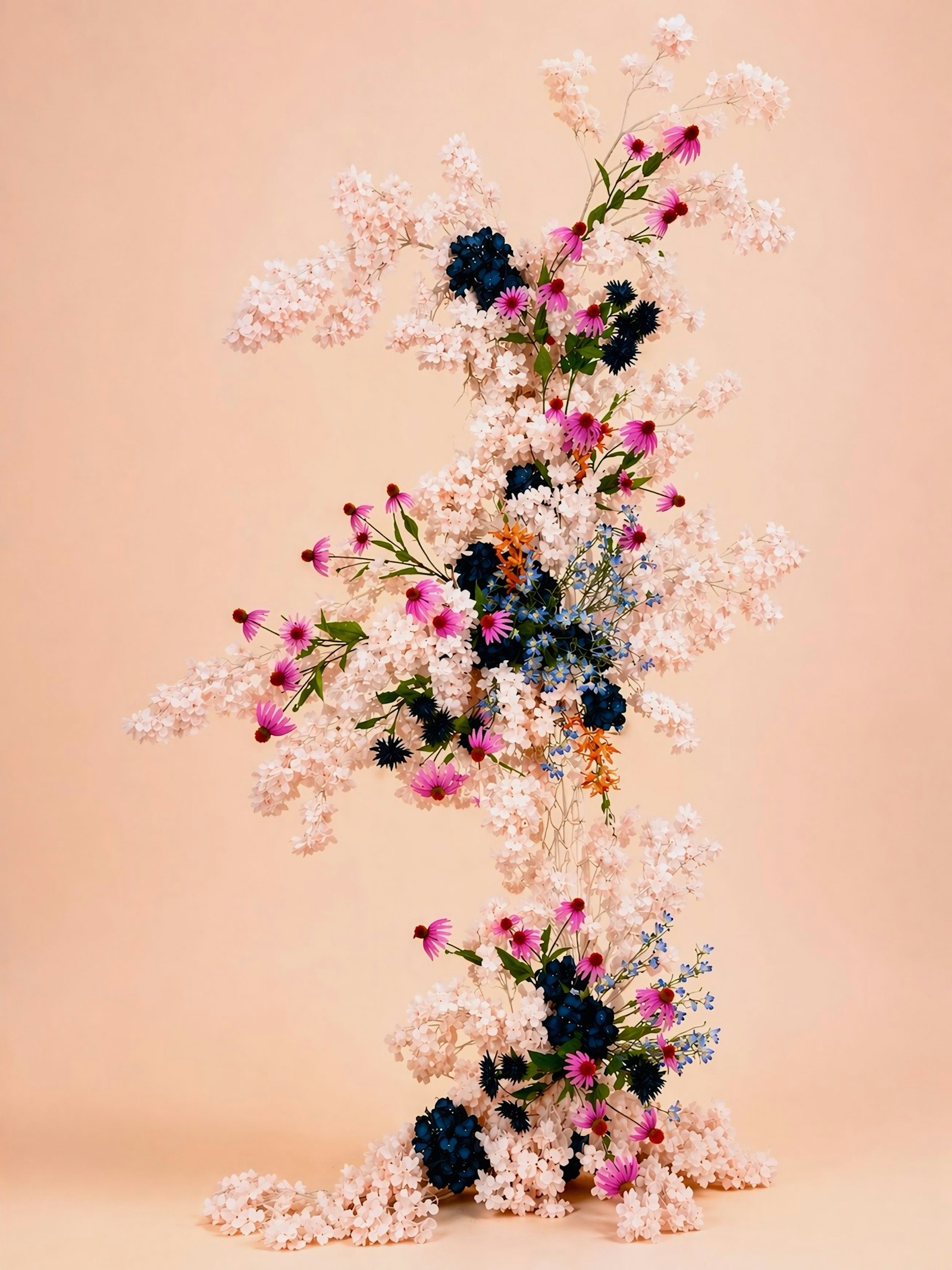 Cascading pink and blue floral wedding arrangement in a pastel garden setting