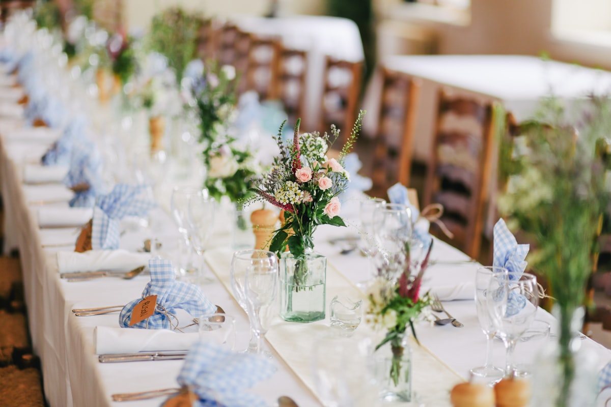 Wedding table centerpiece with white roses and greenery