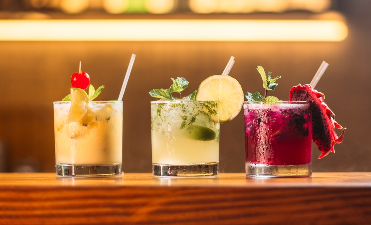 Colorful signature cocktails on a decorated bar with fresh garnishes