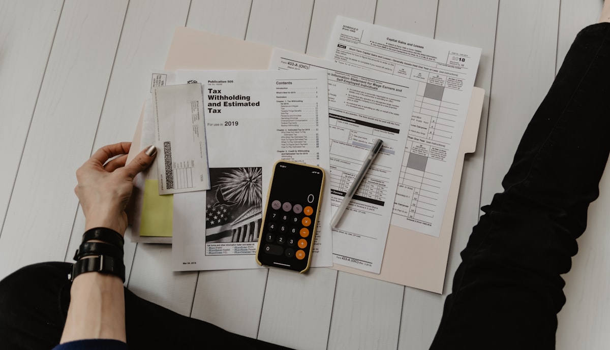 Notebook, calculator and planning notes laid out for budgeting a group trip