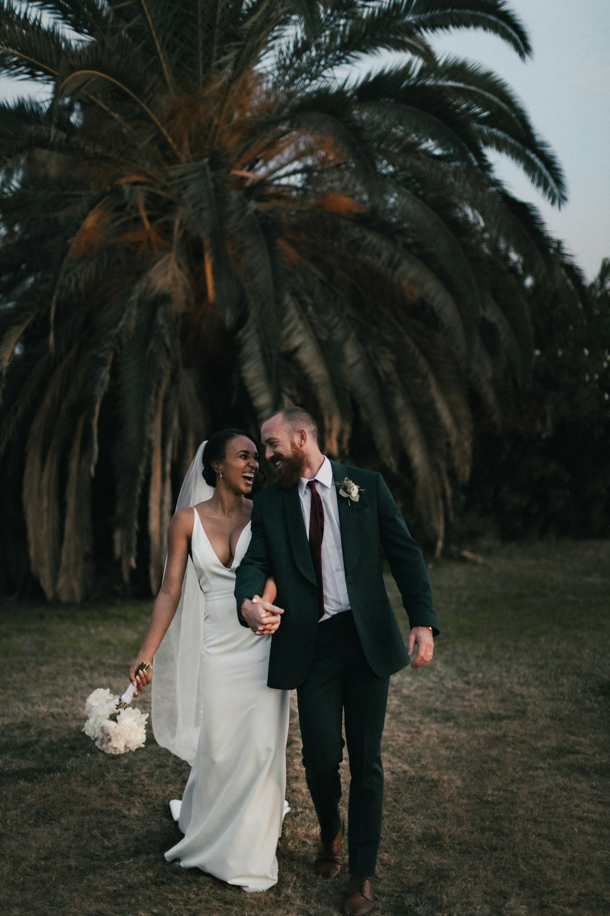 A wedding officiant leading an outdoor ceremony with the couple exchanging vows