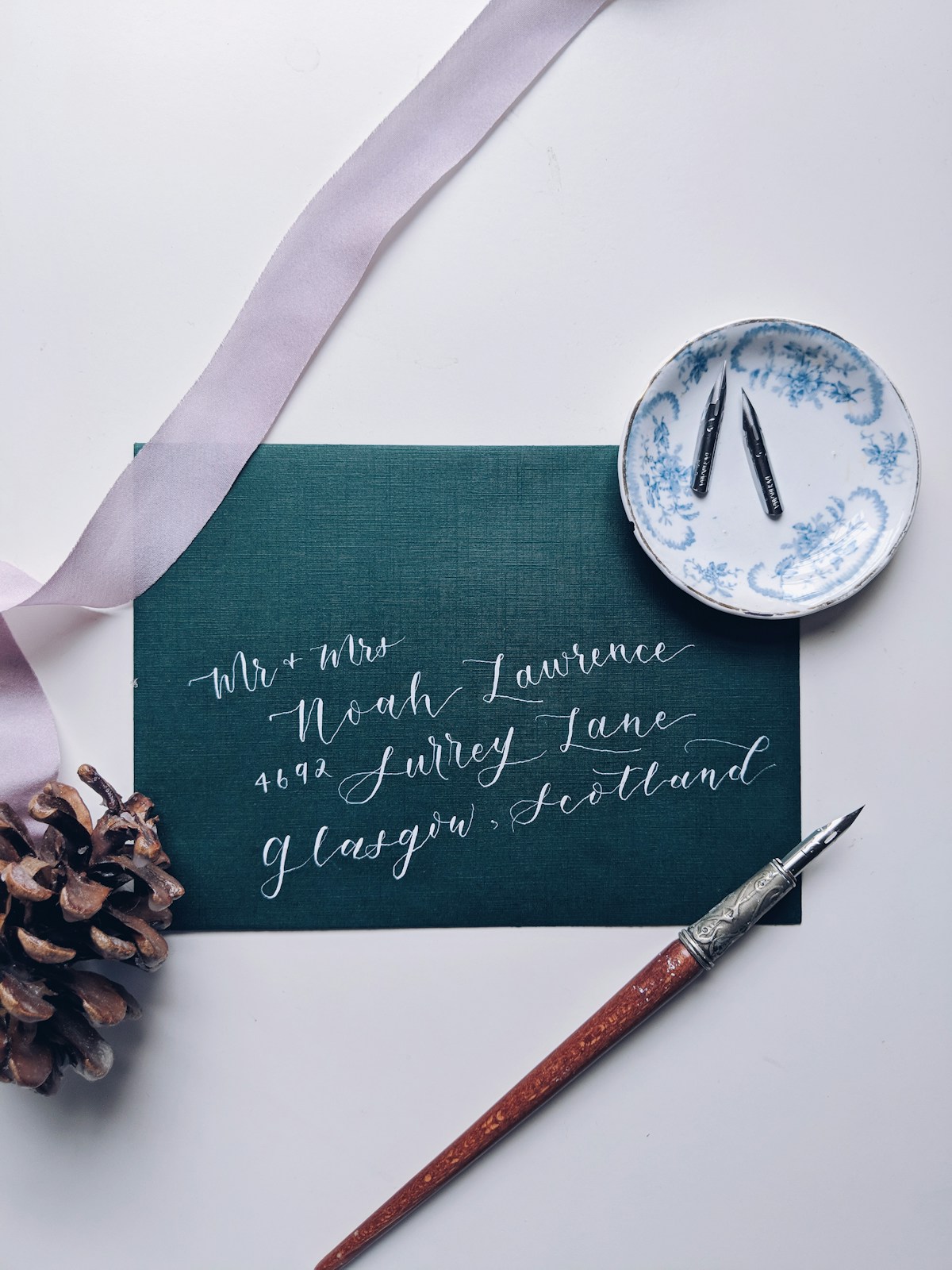 Calligrapher hand-writing a formal wedding invitation envelope in script
