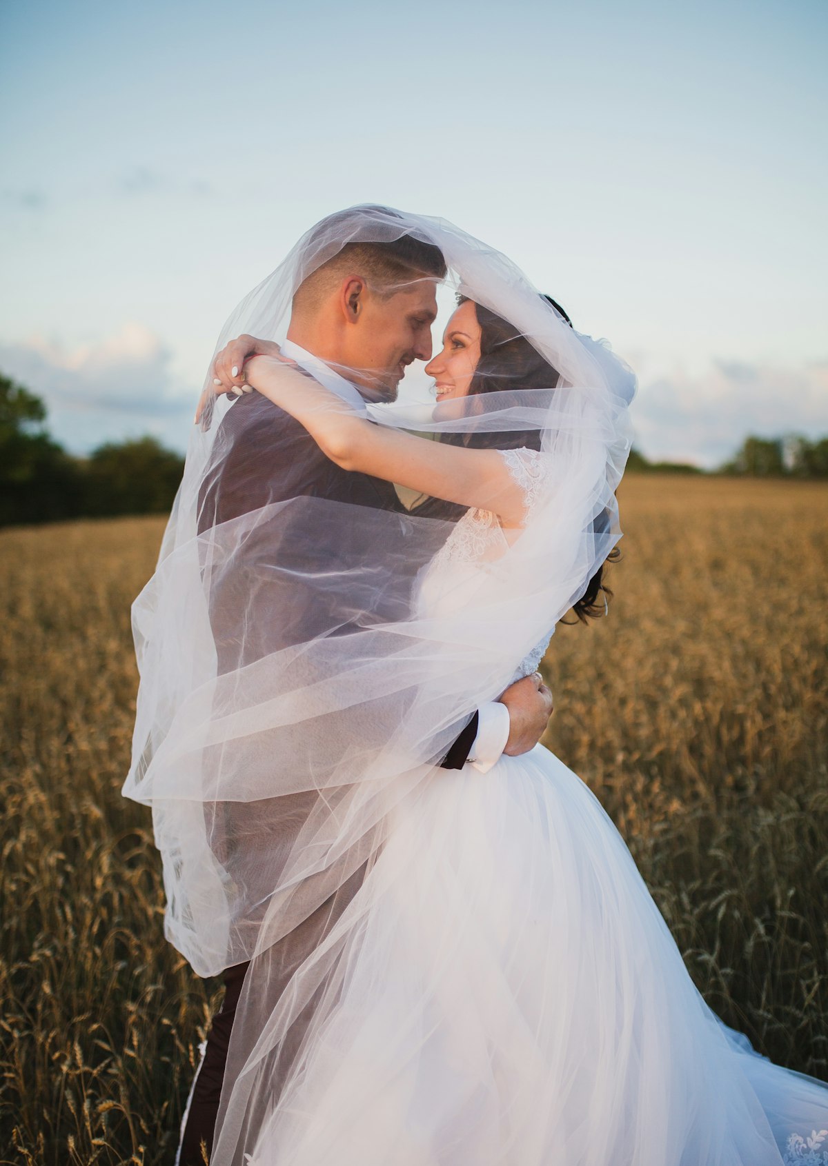 Outdoor summer wedding ceremony with rows of guest chairs arranged on green grass under warm afternoon sunlight