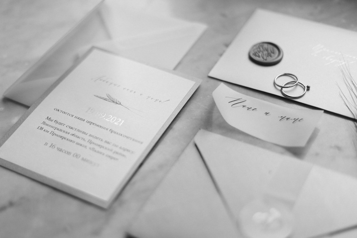 Formal wedding invitation and envelope with rings, a classic monochrome flat lay