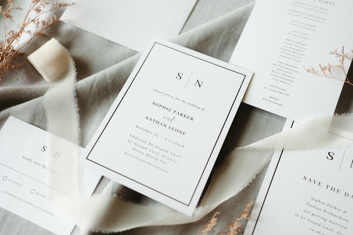 Wedding stationery suite arranged on light fabric with envelopes and printed cards