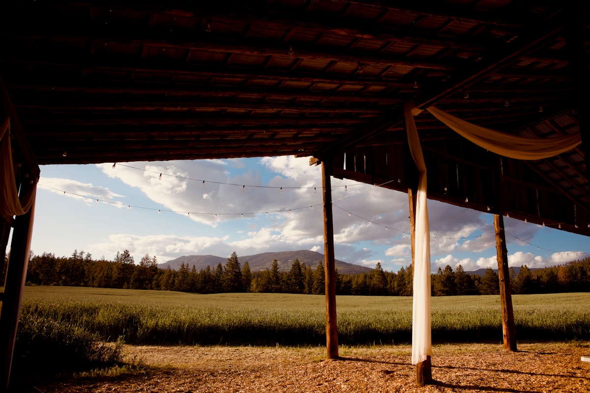 Rustic barn with a green field and distant mountains